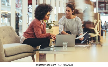 Businesswomen Sharing Ideas Sitting Together With A Laptop On Table. Women Entrepreneurs In A Meeting Sitting In A Lounge At Work Place.