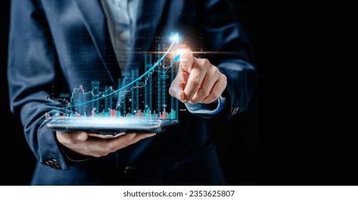 Businesswomen using smartphones trading and point to virtual screens of graph stock market changes, uptrends, growth economic, business strategy development, and find opportunities for investment. - Powered by Shutterstock