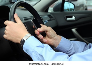 businwssman using  mobile smart phone while driving the car