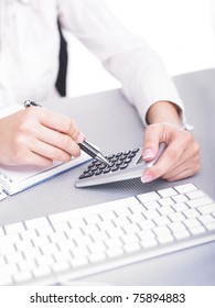 Bussines Woman Calculating With Calculator In Office