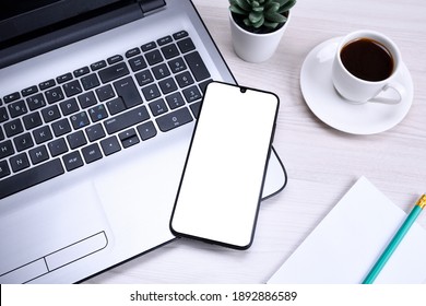 Bussines wooden office desk workplace with blank cellphone, various supplies. School, education, technology and advertisement concept. Mock up. Laptop smart phone, cup of coffe - Powered by Shutterstock - Get 15% off with code: PIKWIZARD15