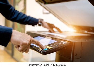Hombre de negocios Botón de presión en el panel de la impresora, el escáner de impresora láser de la máquina de copia de oficina proporciona el concepto de inicio.