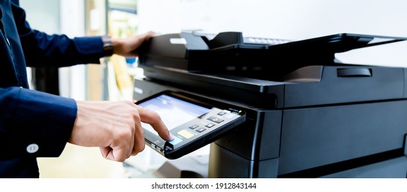 Bussiness man Hand press button on panel of printer, printer scanner laser office copy machine supplies start concept.