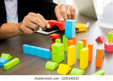 The Bussiness Man Pick Up Block Toys For Complete The Constuction Model In Meeting Room