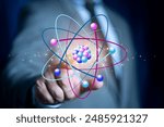 Bussinessman hand holding creative atom on blue background. Nuclear fusion concept, endless energy, cheap electricity, future technologies. Science and future concept 