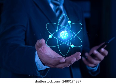 Bussinessman hand holding creative atom on blue background. Nuclear fusion concept, endless energy, cheap electricity, future technologies. Science and future concept  - Powered by Shutterstock