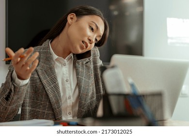 Bussy Asian Woman Worker Talk Phone With Client Sit On Her Workplace In Office. High Quality Photo