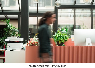 A bussy employee is rushing to the meeting. He is shown in a blurred motion.