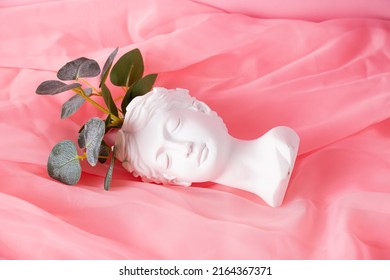 Bust Of A Greek Goddess On A Pastel Pink Background. Minimal Flat Still Life. Beauty Overhead Concept.