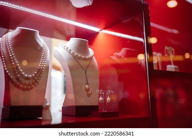 Bust pearl necklace in bright red in a shop window. The concept of discounts and shopping for the holidays. - Shutterstock ID 2220586341