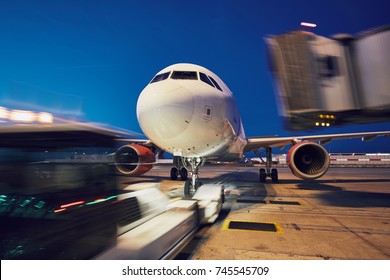 Busy Airport At Night. Push Back Of The Airplane Before Flight.