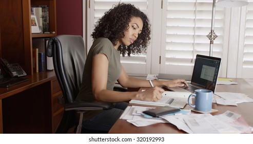 Busy black woman in office doing paperwork