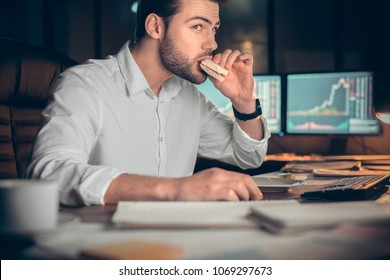 Busy Businessman Having Late Lunch Eating Sandwich In Office Working At Night, Stock Broker Trading Online And Eating Snack Looking At Computer, Workplace Meal, Overwork And Food Delivery Concept