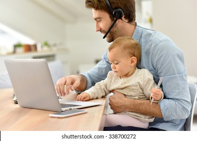 Busy businessman working from home and watching baby 