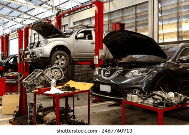 A busy car repair workshop with multiple cars on lifts and tools scattered around, showcasing the environment of automotive maintenance - Powered by Shutterstock