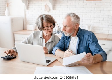 Busy caucasian old elderly senior couple making calculations at home kitchen, checking the document, revising data, information, counting domestic bills and rentals - Powered by Shutterstock