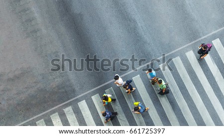 the busy city crowd move to pedestrian crosswalk on business traffic road (Aerial photo, top view)