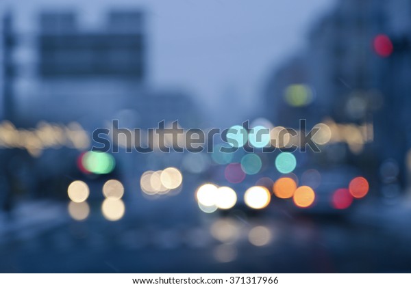 Busy city scene with cars and traffic lights all\
blurred during the night. 