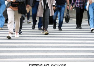 Busy City Street People On Zebra Crossing, Blured Background. Pedestrian Crossing Through A Busy Street