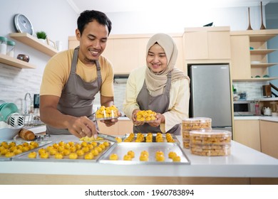 busy couple making nastar snack cake together at home for eid mubarak celebration together