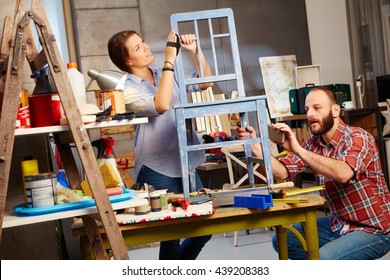 Busy Couple Renewing Chair In Home Workshop.