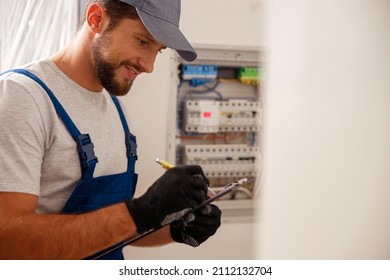 Busy Electrical Technician Writing On A Clipboard The Data Collected On A Residential Electric Panel