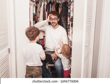 Busy Father Trying To Find A Quiet Place In A Wardrobe  To Hide From Children For A Work At The Laptop. Stay Home Concept. Quarantine. Freelancer.