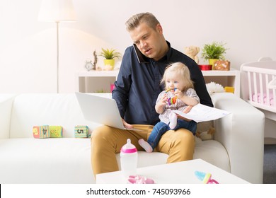 Busy father working with computer while looking after his baby girl - Powered by Shutterstock