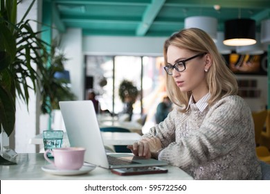 Busy Female Student Preparing For Exam In Cafe