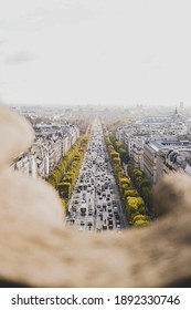 A busy Champs-Élysées filled with cars as viewed from Arc de Triomphe. 
