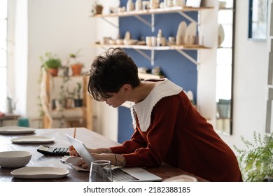 Busy Focused Pottery Workshop Manager Doing Bookkeeping, Tracking Income And Expenses, Female Entrepreneur Ceramic Shop Owner Working With Financial Statements, Tracking Sales In Retail Store