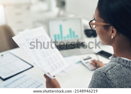Busy with her tax return filing. Closeup shot of an unrecognisable businesswoman calculating finances in an office.