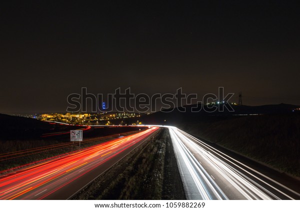 A busy highway\
with cars flowing at night