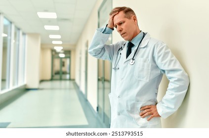 In a busy hospital corridor, a compassionate doctor experiences intense stress and deep contemplation, showcasing the emotional challenges healthcare professionals face in commitment to patient care - Powered by Shutterstock