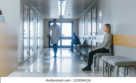 Busy Hospital Hallway. Medical Personnel, Doctors, Nurses, Surgeons Walking, Female Patient Waiting Her Turn. Modern Medical Facility.