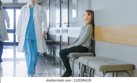 Busy Hospital Hallway. Medical Personnel, Doctors, Nurses, Surgeons Walking, Female Patient Waiting Her Turn. Modern Medical Facility.