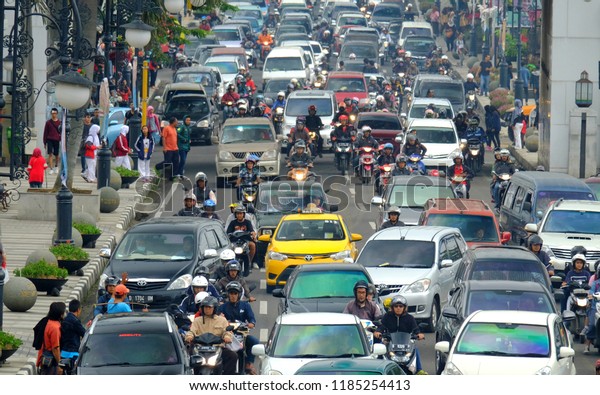 Busy hour in Asia Afrika Street, in\
Bandung, Indonesia. With many motorcycles and cars in the road.\
Bandung,West Java, Indonesa, March, 5, \
2016