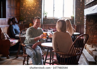 Busy Interior Of Traditional English Pub With Friends Meeting For Drinks