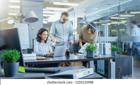 Busy International Office Where Diverse Team Of Young Businesswomen And Businessmen Work On Laptops, Have Meetings, Discussions And Draw Plans On A Whiteboard.