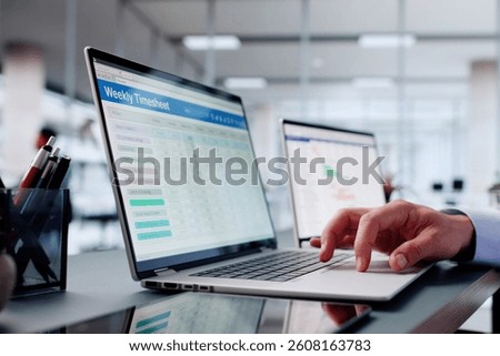 Busy Man In Office Using Computer To Track Weekly Schedule.