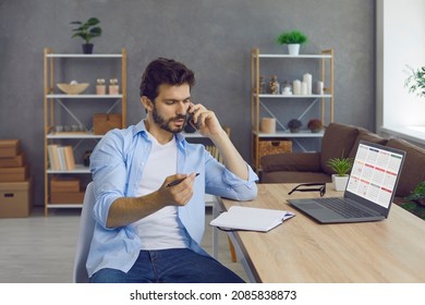 Busy man sitting at desk, talking on phone, discussing agenda, work schedule and job deadline, telling about business meeting, arranging social event, choosing convenient time, using smart PC calendar