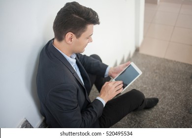 Busy man using tablet on stairs