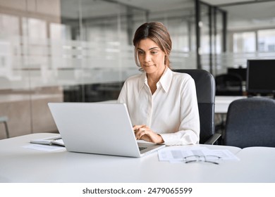 Busy middle aged business woman executive using laptop working in office. Mature businesswoman entrepreneur at work, professional female bank hr manager looking at computer communicating with clients. - Powered by Shutterstock