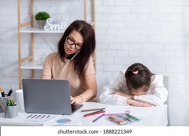 Busy mom working on laptop and talking on phone at home, lonely depressed child sitting nearby. Young mother having no time for child with her online job during covid-19 quarantine