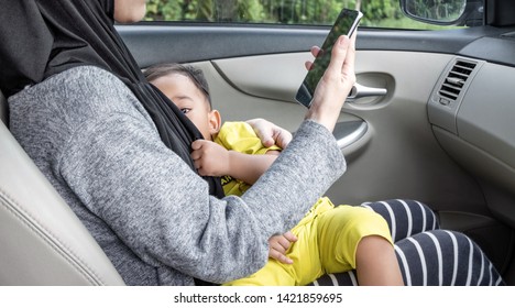 Busy Mother Give Breastfeeding While Talking On Phone In Car.