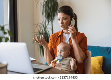 Busy mother talking on the phone while babysitting her daughter and working at home. - Powered by Shutterstock