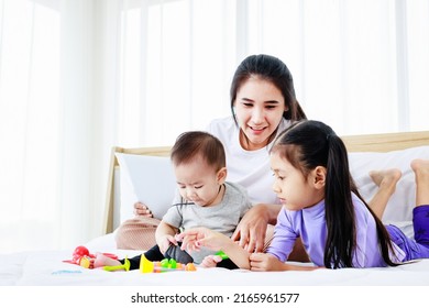 Busy Mother With Two Daughters Multitasking With Laptop, Super Mom Concept