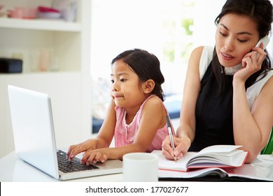 Busy Mother Working From Home With Daughter