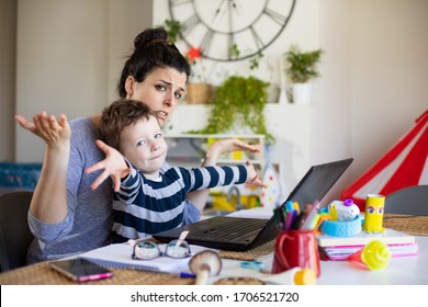 Busy Mother Working From Home And Taking Care Of Her Child. Stressed Woman Telecommuting On Laptop Computer With Her Son.