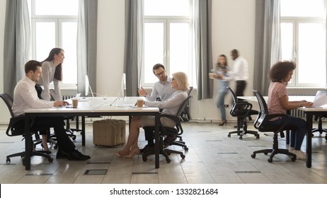 Busy Multicultural Enterprise Employees Sitting At Desks Working On Computers In Modern Office Rush, Staff Business People Company Workers Moving Talking In Big Corporate Coworking Open Space Room